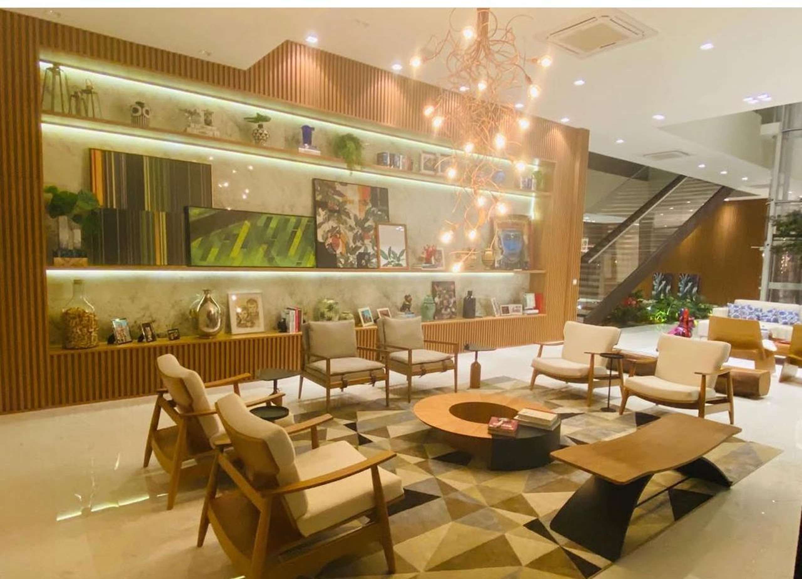 MS-Zappa-Sorocaba-Living-social-com-prateleiras-iluminadas-poltronas-confortaveis-e-decoracao-sofisticada-em-madeira-1