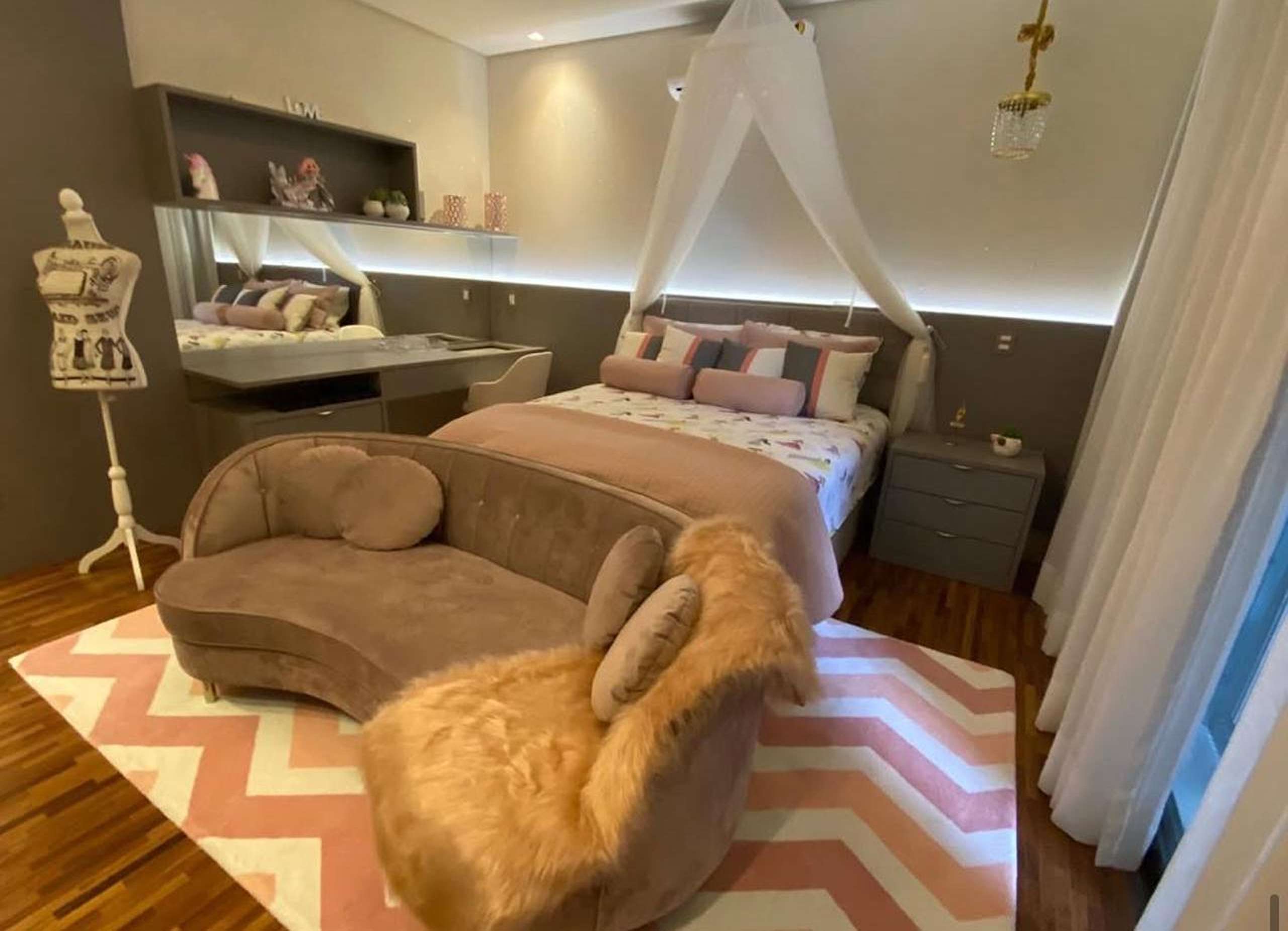 MS-Zappa-Sorocaba-Quarto-elegante-mobiliado-com-tons-rosa-poltrona-confortavel-tapete-zig-zag-e-iluminacao-indireta-1