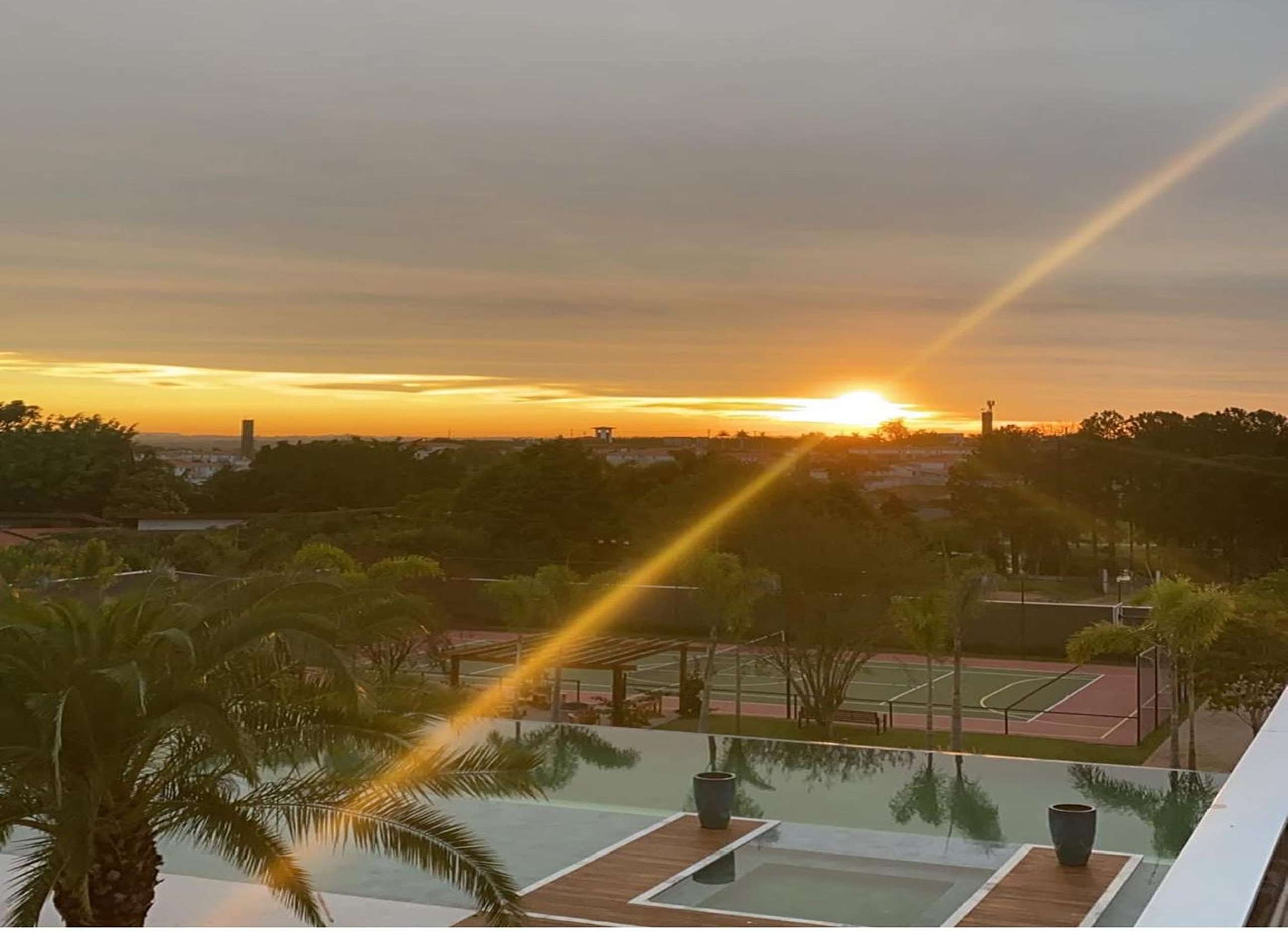 MS-Zappa-Sorocaba-Vista-externa-do-por-do-sol-sobre-a-piscina-quadras-esportivas-e-vegetacao-tropical